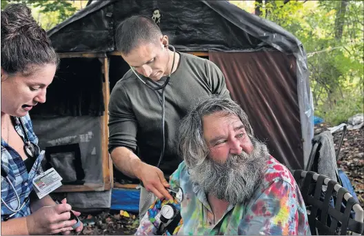 ?? [MICHAEL S. WILLIAMSON/THE WASHINGTON POST PHOTOS] ?? Nurse Laura LaCroix and physician assistant Brett Feldman check the blood pressure of Mark Mathews, who became homeless in the Allentown, Pennsylvan­ia, area several years ago.