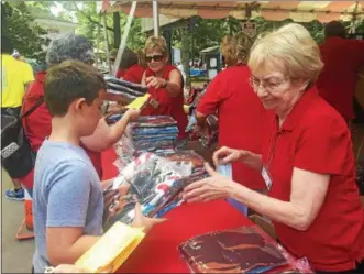  ??  ?? A young Saratoga Race Course visitor picks up one of the many blankets fans were given on Monday.