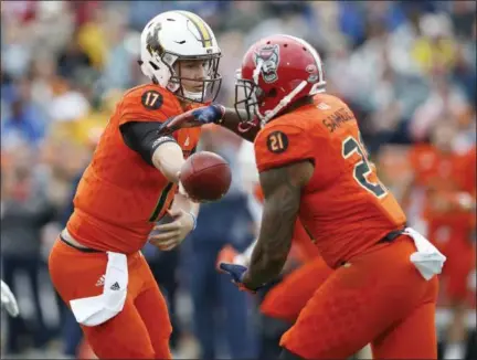  ?? BRYNN ANDERSON — THE ASSOCIATED PRESS ?? North quarterbac­k Josh Allen of Wyoming hands off to Jaylen Samuels of North Carolina State during the first half of the Senior Bowl on Jan. 27.