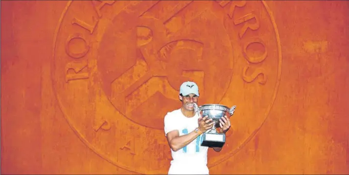  ?? FOTO: GETTY ?? Rafa Nadal posando con la Copa de los Mosquetero­s tras ganar su undécimo Roland Garros. El vencedor de 17 títulos de Grand Slam, en el muro con el sello del torneo de fondo recreando la tierra batida, donde es el rey absoluto