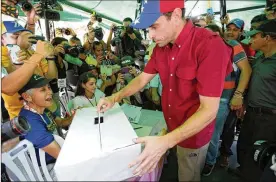  ?? ARIANA CUBILLOS / AP ?? Opposition leader Henrique Capriles casts his ballot during a symbolic referendum in Caracas, Venezuela, on Sunday. Participat­ion appeared to be high, with large crowds of people lining up at tables in churches and parks across the capital.