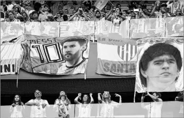  ?? GIUSEPPE CACACE/GETTY-AFP ?? Argentina fans in Russia display images of Argentine soccer legends Lionel Messi, left, and Diego Maradona.