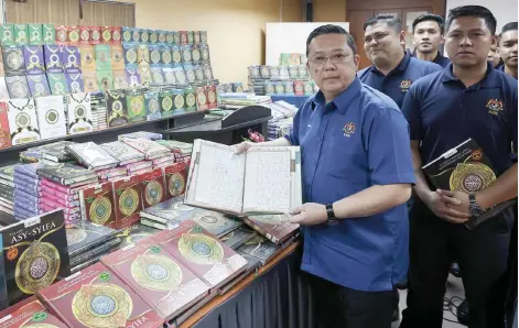  ?? — Bernama photo ?? Nik Yusaimi showing some of the seized copies of al-Quran and reading materials at the press conference in Butterwort­h on Wednesday.