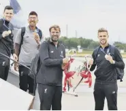  ??  ?? 0 Virgil Van Dijk sticks his tongue out as he lifts the Champions League trophy. Left, Jurgen Klopp and Jordan Henderson carry the silverware off the plane home from Madrid.