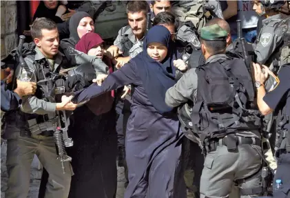  ?? AFP ?? Clima de tensión.
Una mujer palestina quiere avanzar ante un muro de policías israelíes en la Explanada.