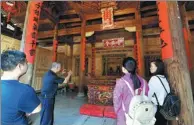  ?? ZHANG BIN / CHINA NEWS SERVICE ?? Left: A senior tells tourists the story of the Pu Zhao Tang Temple in Yangchun.
