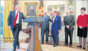  ?? AP ?? President Donald Trump gives the podium to commerce secretary Wilbur Ross (third from left) while signing executive orders regarding trade in the Oval Office on Friday.