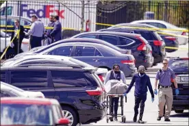  ?? MICHAEL CONROY / AP ?? A body is taken from the scene where multiple people were shot at a FedEx Ground facility in Indianapol­is on Friday. A gunman killed several people and wounded others before taking his own life in a late-night attack, police said.