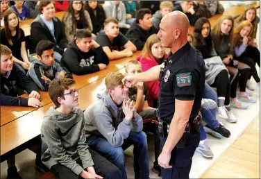  ?? NWA Democrat-Gazette/DAVID GOTTSCHALK ?? Cpl. David Faulk, student resource officer with the Prairie Grove Police Department, makes a gesture towards Davis Stephens, an eighth-grader, as he speaks Tuesday during an active shooter training assembly at Prairie Grove Middle School. The system,...