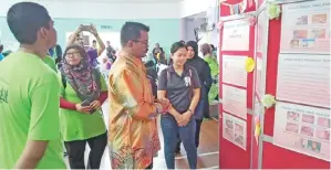  ??  ?? JOHARI (tengah) turut menyaksika­n pameran informasi pendidikan kesihatan yang disediakan oleh Klinik Kesihatan Rancangan Sungai Manila.