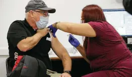  ?? Jerry Lara / Staff photograph­er ?? Jay Flexner gets the Moderna COVID-19 vaccine administer­ed by Maribel Hernandez at Wonderland of the Americas mall.