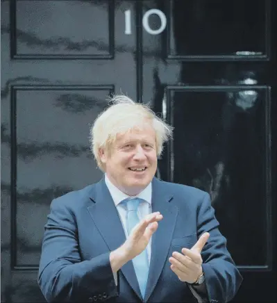  ?? PICTURE: AARON CHOWN/PA WIRE ?? UNSCATHED: Boris Johnson stands in Downing Street last night to applaud NHS workers fighting the pandemic.