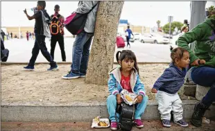  ?? SANDY HUFFAKER PHOTOS / THE NEW YORK TIMES ?? Undocument­ed migrants wait for asylum hearings outside the port of entry in Tijuana, Mexico, on Wednesday. President Donald Trump caved to enormous political pressure Wednesday and signed an executive order that ends the separation of families by...