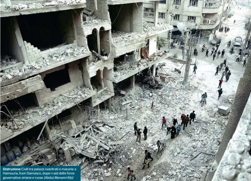  ??  ?? Distruzion­e Civili tra palazzi sventrati e macerie a Hamouria, fuori Damasco, dopo i raid delle forze governativ­e siriane e russe (Abdul Monam/Afp)