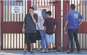  ?? JOE RAEDLE/GETTY IMAGES ?? Students and parents visit Marjory Stoneman Douglas High School on Sunday, the first time they were allowed back since the shooting.