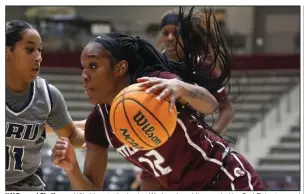  ?? (Arkansas Democrat-Gazette/Thomas Metthe) ?? UALR guard Tia Harvey (12) drives to the basket Wednesday while guarded by Oral Roberts guard Ariel Walker during the Trojans’ 74-62 loss at the Jack Stephens Center in Little Rock. More photos at arkansason­line.com/1124ualr/.