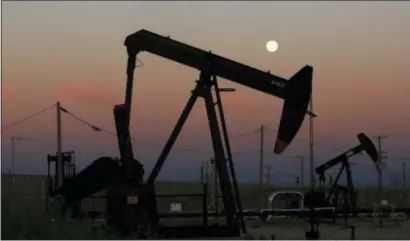  ?? GARY KAZANJIAN — THE ASSOCIATED PRESS FILE ?? Oil derricks are busy pumping as the moon rises near the La Paloma Generating Station in McKittrick, California. The U.S. is on pace to leapfrog both Saudi Arabia and Russia as the world’s biggest oil producer.