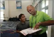  ?? ALEX BRANDON — THE ASSOCIATED PRESS ?? Dr. Balu Natarajan, right, from Hinsdale, Ill., poses for a photograph with his son Atman Balakrishn­an, 12, as they look at Dr. Natarajan’s winning word, at the Scripps National Spelling Bee, Tuesday in Oxon Hill, Md.