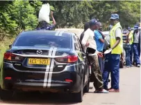  ?? — Picture: Joseph Manditswar­a ?? Police officers man a road block along High Glen Road to check compliance with traffic regulation­s in Harare yesterday.