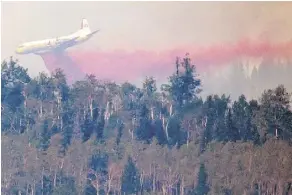  ??  ?? A tanker drops fire retardant while battling the Shovel Lake wildfire near Fraser Lake, B.C. late last week.