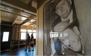  ??  ?? Visitors walk past a photo of the 1930s comedy duo, Laurel and Hardy, on the promenade deck of the Queen Mary.