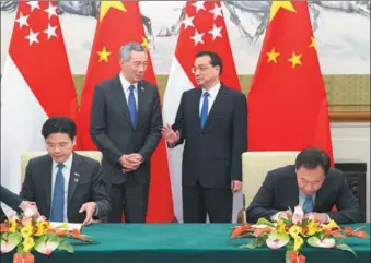  ?? WANG YE / XINHUA ?? Premier Li Keqiang talks with visiting Singapore Prime Minister Lee Hsien Loong during the signing of two documents on third market cooperatio­n and culture heritage protection between the two countries.