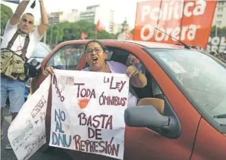  ?? / AP ?? Una mujer exhibe un cartel, frente al Congreso, contra las leyes propiciada­s por Milei.