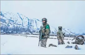  ??  ?? Security personnel stand guard near a site of a gunbattle between suspected militants and forces at Khrew area of Pampore in Pulwama district, Srinagar, on Tuesday.
AFP