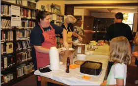  ?? SUBMITTED PHOTOS ?? Jessica Conlin and Lois Hertzog dip ice cream and Al Muller adds peaches during First Reformed Church’s Peach Festival on Aug. 12.