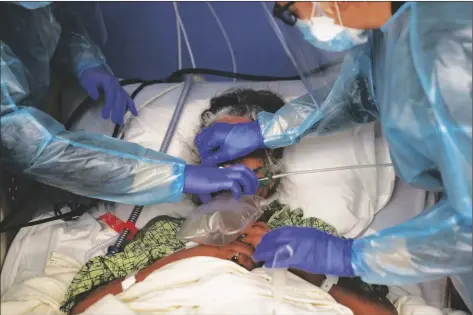  ?? AP PHOTO/JAE C. HONG ?? Two nurses put a ventilator on a patient in a COVID-19 unit at St. Joseph Hospital in Orange, Calif. on Jan. 7, 2021.