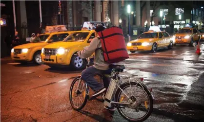  ?? Photograph: Alamy Stock Photo ?? A delivery person waits for traffic on his electric powered bicycle in New York City.