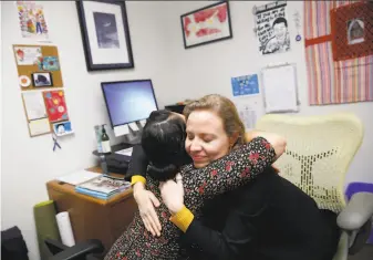  ?? Lea Suzuki / The Chronicle ?? Kelly Wells (right), deputy public defender, and immigratio­n social worker Edie Castellon hug during an emotional moment over clients’ cases at the public defenders office in S.F.