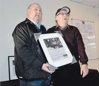  ?? MIKE LACEY PETERBOROU­GH THIS WEEK ?? Retired CHEX-TV sportscast­er Gary Dalliday accepts a plaque from Petes director Ken Jackman Tuesday .