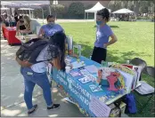  ??  ?? Chico State freshman Britney Jimate, left, writes her name down for the Child Developmen­t Student Associatio­n while speaking with Child Developmen­t Student Associatio­n member Elenie Perez and faculty advisor Lindsey Nenadal at the Student Life and Leadership “clubtacula­r” student involvemen­t fair Wednesday at Chico State in Chico.