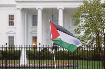  ?? AFP PIC ?? A Palestinia­n flag being waved outside the White
House in Washington during a protest calling for a ceasefire in Gaza on Saturday.