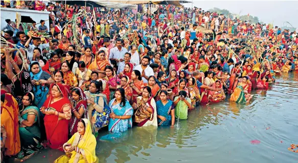  ??  ?? Divine light Hindu devotees offer prayers to the sun god in the Yamuna river at the climax of the Chhath Puja festival in Allahabad, India, yesterday.