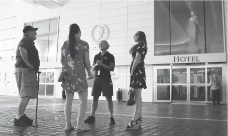  ?? TAYLOR CAMPBELL ?? Rick Malewicz, left, and his daughters Morgan and Kendal, right, speak to a Caesars Windsor employee on Thursday during the casino’s first day open after a 60-day strike. The family enjoys lunch at the Spago restaurant, and were excited to “have...