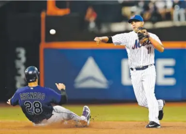  ??  ?? Mets shortstop Ruben Tejada forces out Rockies third baseman Nolan Arenado during the fourth inning Monday night. After taking a 2-1 lead in the fourth, the Rockies didn’t score the rest of the game. Rich Schultz, Getty Images