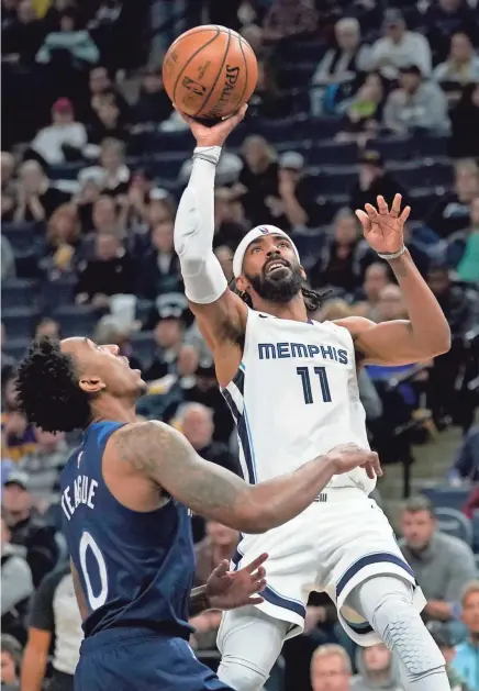  ??  ?? Grizzlies guard Mike Conley (11) shoots over the Timberwolv­es guard Jeff Teague (0) during the third quarter on Sunday. The Grizzlies won 100-87. HANNAH FOSLIEN/AP