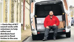  ??  ?? > Gavin Key of RCT council works with volunteers to help collect and distribute food parcels to flood victims in the area