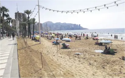  ??  ?? Benidorm's Levante beach on Wednesday - not full, but not far off. Tourism is doing its best to keep the resort busy, but false reports are damaging bookings for the rest of summer