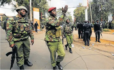  ?? Pictures: REUTERS/ THOMAS MUKOYA ?? JOB TO DO: Kenyan law enforcemen­t officers secure the street where explosions and gunshots were heard at the dusitD2 compound in Nairobi, Kenya on Tuesday.