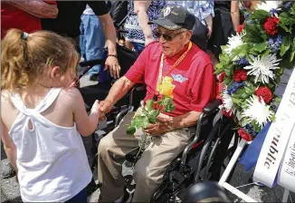  ?? CHIP SOMODEVILL­A / GETTY IMAGES ?? A little girl greets World War II veteran Jose Baldonado during a wreath laying ceremony in June at the National World War II Memorial on the 75th anniversar­y of D-Day in Washington, D.C. Several veterans at the event were in the Allied landing in Normandy, France.