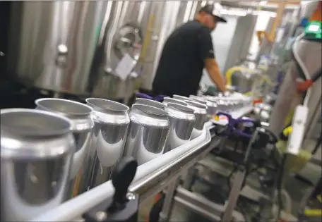  ?? Justin Sullivan Getty Images ?? PRESIDENT TRUMP in March announced a 10% tariff on aluminum. Above, beer cans at Devil’s Canyon Brewery in San Carlos, Calif.