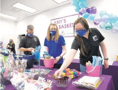  ?? PHOTOS BY PAUL W. GILLESPIE/CAPITAL GAZETTE ?? KCW Engineerin­g Technologi­es employees Jeff Kreise, from left, Jen Clay and Sarah Yarbrough assemble Easter baskets, called Amy’s Baskets, for clients of the House of Ruth, from donations by the KCW and a group of schoolchil­dren.