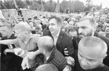  ??  ?? Saakashvil­i is surrounded by his supporters as he arrives at a checkpoint on the Ukrainian-Polish border in Krakovets, Ukraine. — Reuters photo