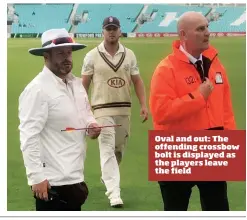  ??  ?? Oval and out: The offending crossbow bolt is displayed as the players leave the field