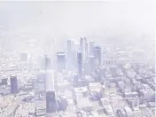  ?? ROBERT DURELL TNS ?? An aerial view of the Los Angeles skyline covered in smog, looking east, in an August 1990 file image.