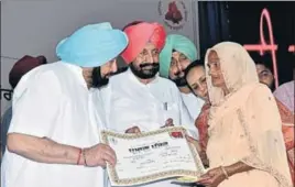  ??  ?? ■ Chief minister Captain Amarinder Singh handing over a certificat­e to a government scheme beneficiar­y in Mohali on Tuesday. HT PHOTO