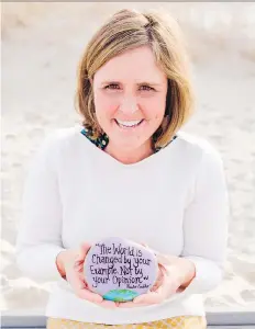  ??  ?? Megan Murphy paints positive messages on rocks for strangers to find.